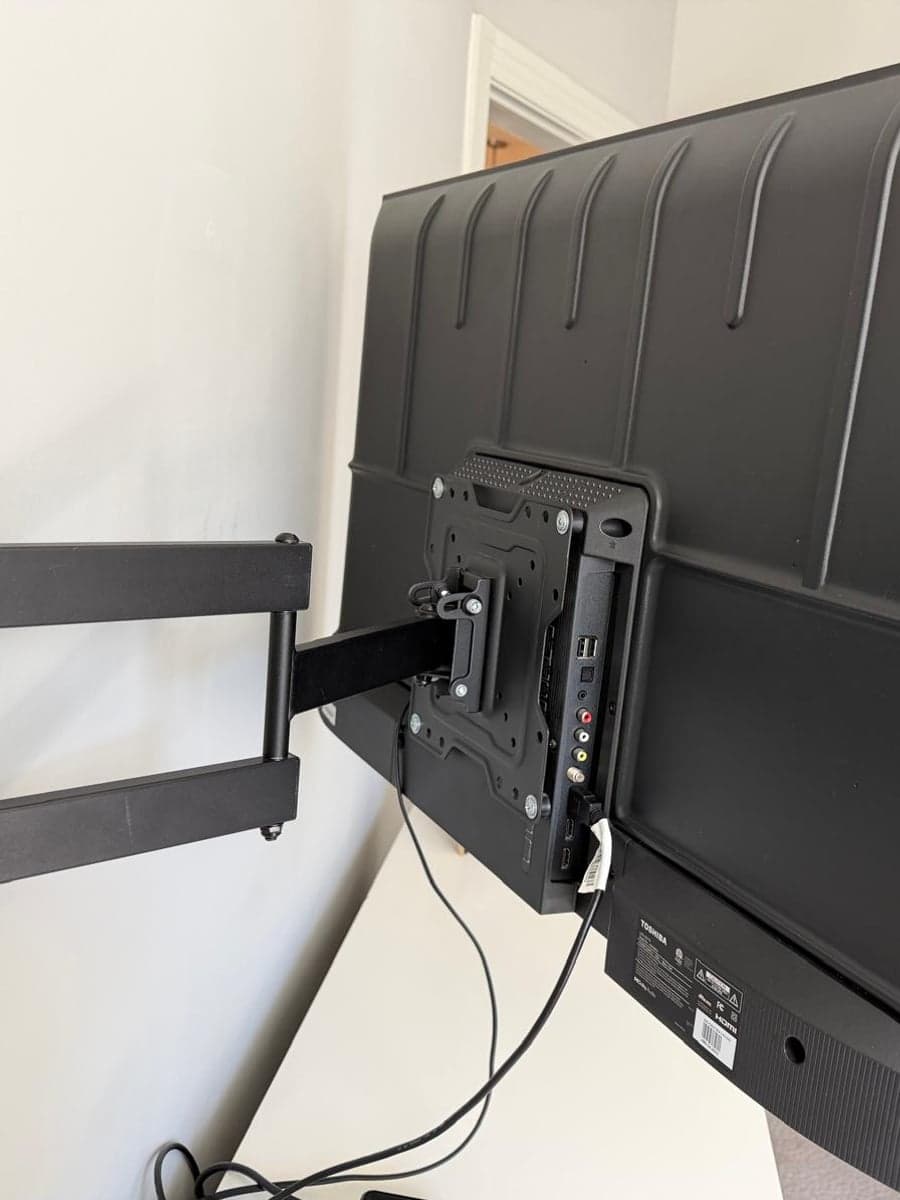 Wall, bracket and the back of a mounted television after cleaning