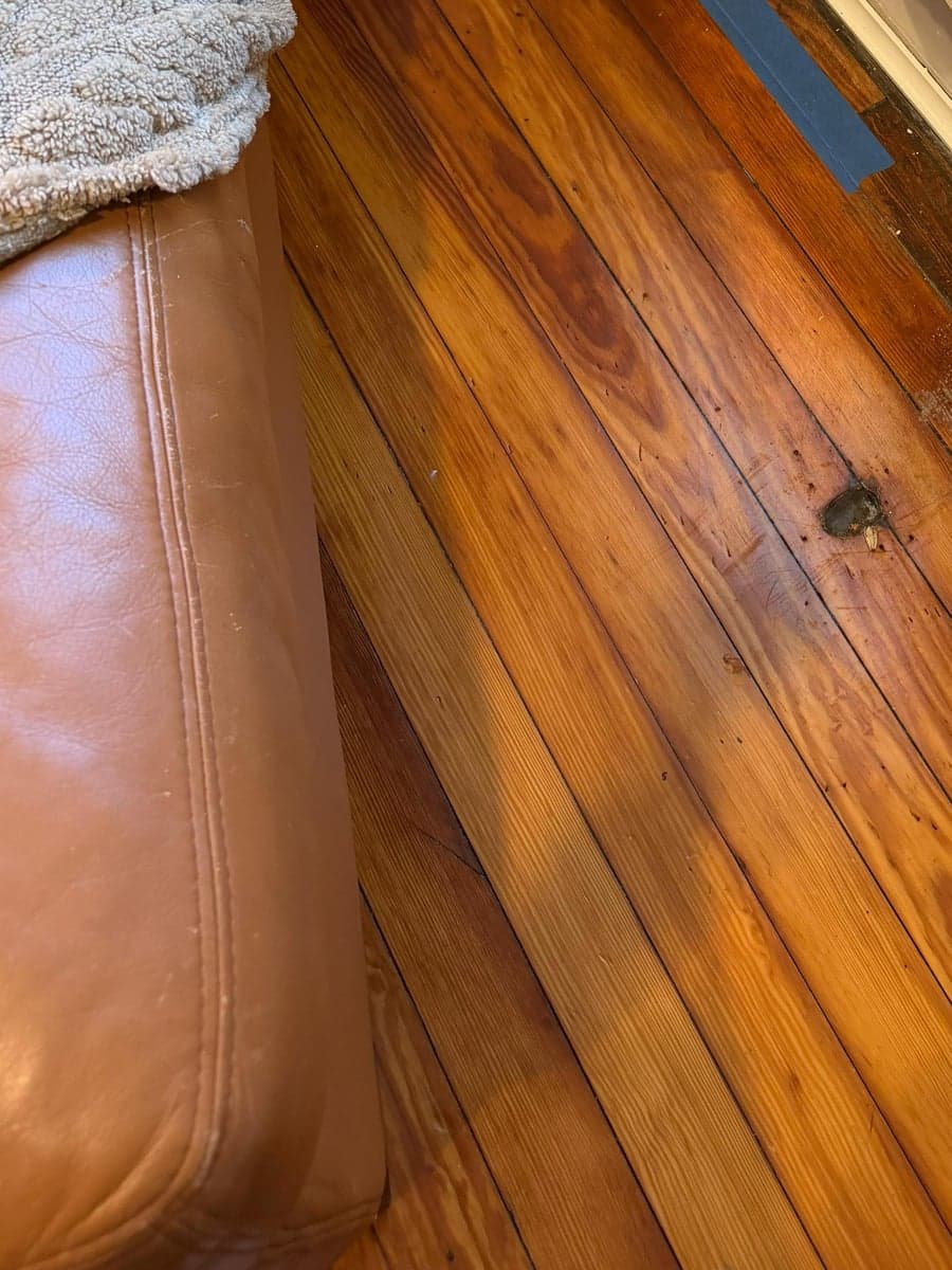 Hardwood boards cleaned in under the base of a sofa